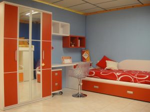 Dormitorio juvenil con armario con puertas plegables, mesa de escritorio y cama nido con arcón